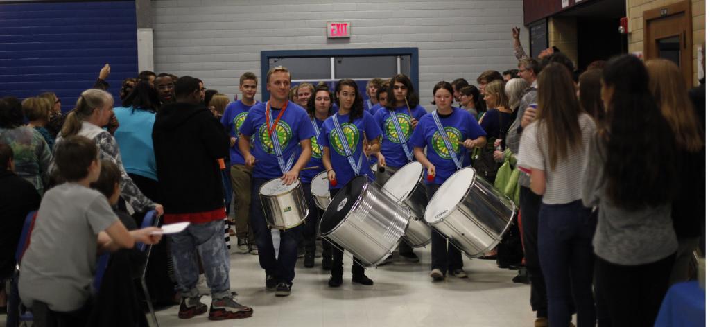 Percussion teacher Matt Ehlers leads the Samba Knights in its procession into the cafeteria for a performance at the annual Knights of Steel dessert concert Nov. 24. The group played some of their sets for students at lunch last week in addition to at the concert. Photo by Aiden Foster.
