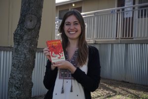 Ms. Olson poses with a copy of Catcher in the Rye. Photo by Madison Olsen