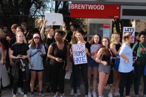 After walking out of the beginning of fourth period class, students of an organization called the McCallum Justice Coalition wait at the city bus station at Lamar and Koenig, where they caught the bus to Auditorium Shores to join Inauguration Day protests. As they marched to the bus stop, the students chanted “Love Trumps Hate” and “This is What Democracy Looks Like.” Photo by Madison Olsen.