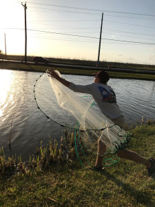 Sam Stone throws a castnet to catch fish bait while on a family trop to Port Aransas. Photo by Charlie Stone. 