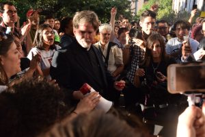 May Day activists cheer Rev. Jim Rigby of St. Andrews Church after state troopers released him. Photo by Diego Guttierrez.