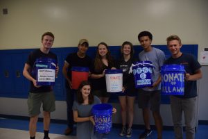 PALS members, Cristain Miranda, Atley Brown, Alana Raper, Charlie Holden, Noah Savage, Eric LaWare and Sam Stone, pose outside Mr. Cowles’ room with the five-gallon buckets they used to collect donations during the shower strike. Photo by Gregory James.