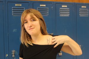 Senior Oona Moorhead shows her tattoo of a devil on her left shoulder. The devil was her fourth tattoo. "My aunt is an artist, and when she was in grad school she used to draw all these devils all the time, so when I was a little kid I just had all these devils everywhere,” Moorhead said. “I really liked it, so I got one of those.” Photo by Charlie Holden.