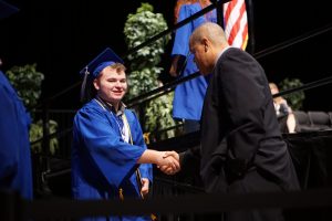 Creedle greets Mr. Featherstone after walking across the Frank Erwin Center stage at the commencement ceremony on Thursday. Photo by Dave Winter.